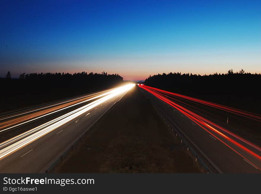 A long exposure of a highway at night with the light trails of the passing traffic. A long exposure of a highway at night with the light trails of the passing traffic.