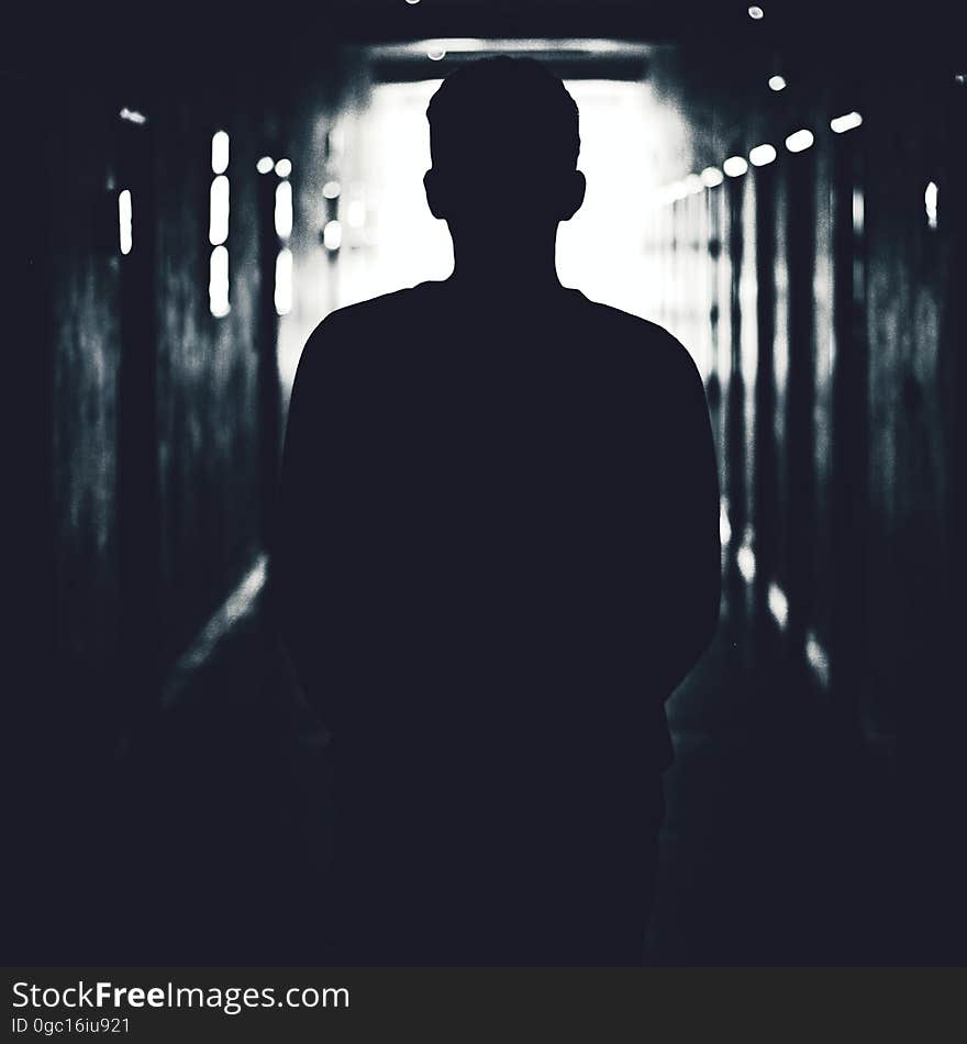 The silhouette of a man standing in a dark tunnel. The silhouette of a man standing in a dark tunnel.