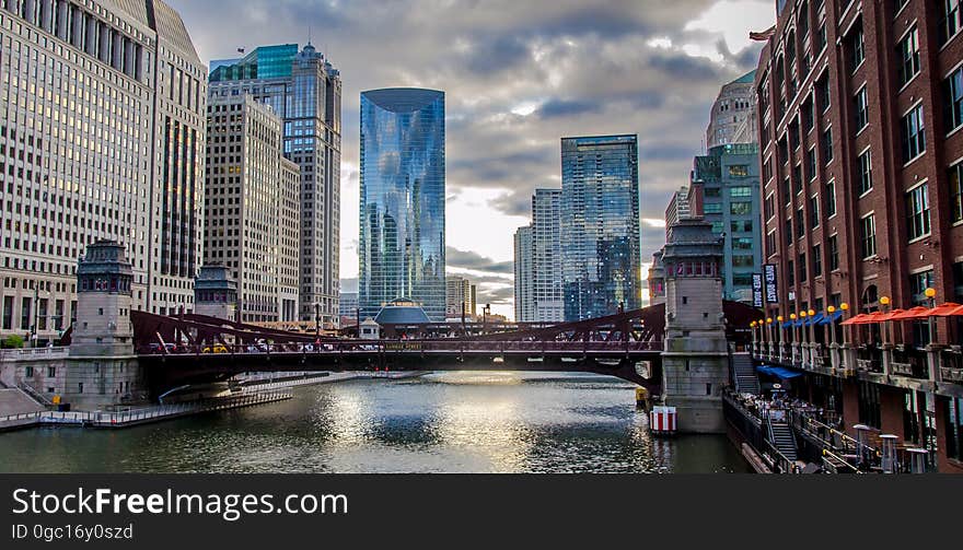 Skyline of city along waterfront with bridge against cloudy skies. Skyline of city along waterfront with bridge against cloudy skies.