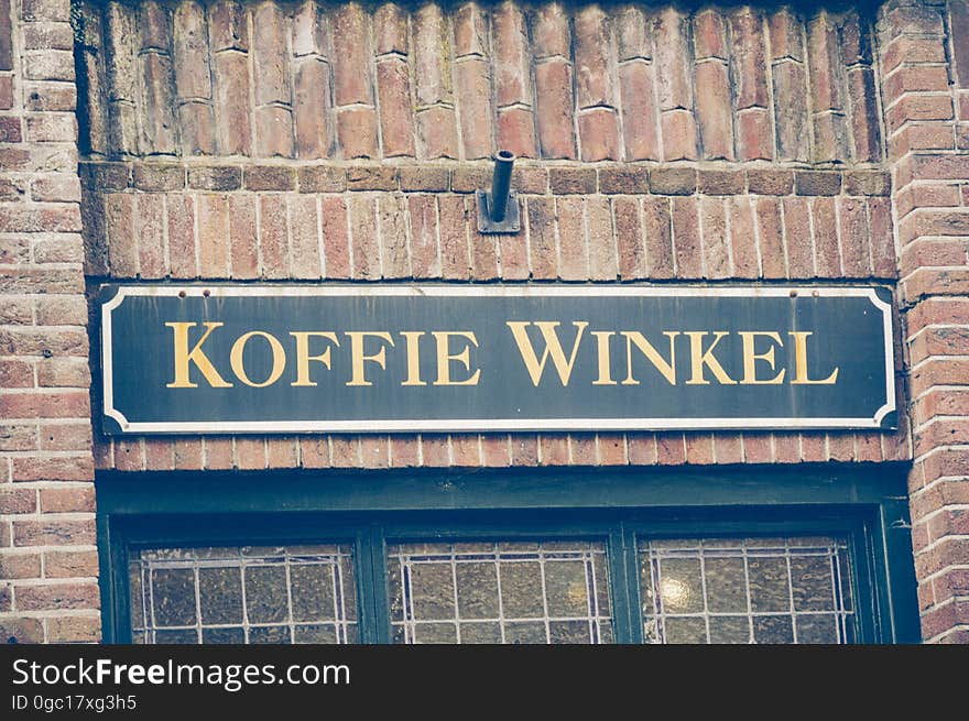 Sign with Koffie Winkel on exterior of brick building. Sign with Koffie Winkel on exterior of brick building.