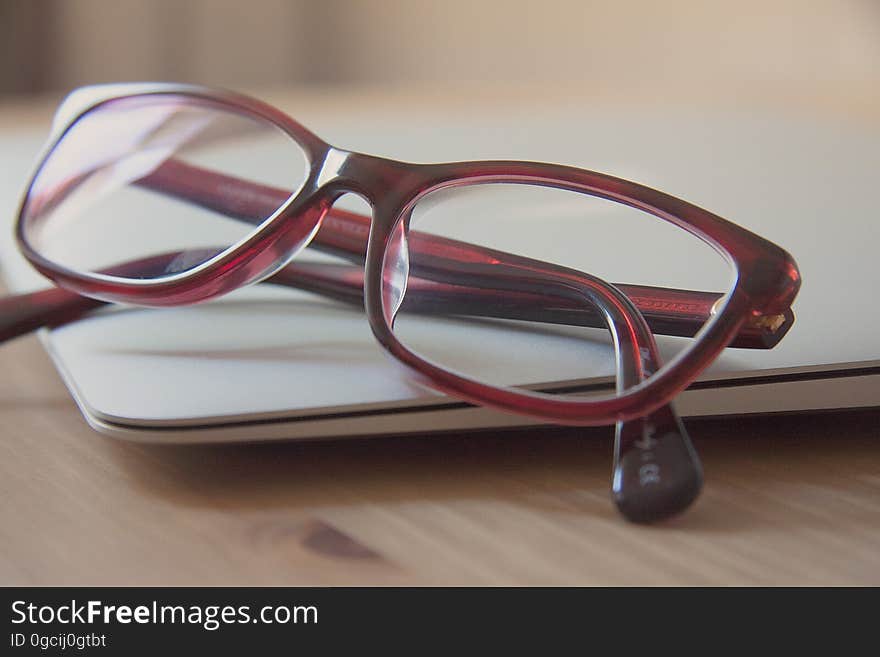 Folded eyeglasses on closed laptop computer. Folded eyeglasses on closed laptop computer.