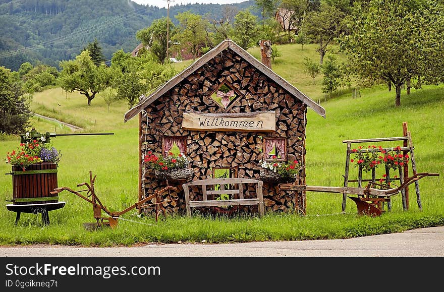 Rustic woodshed in countryside with welcome sign on sunny day. Rustic woodshed in countryside with welcome sign on sunny day.