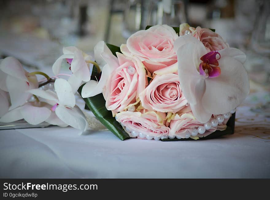 Close up of bridal bouquet with pink roses and orchids.