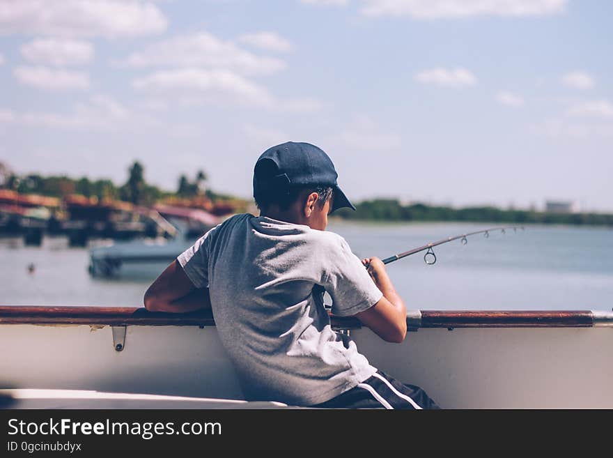 A boy fishes on a dock. A boy fishes on a dock.