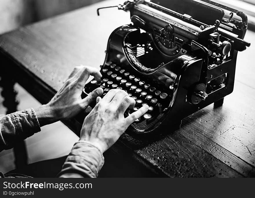 The hands of an elderly person typing on an old fashioned typewriter which used ribbon (here paper is absent from the carriage). The hands of an elderly person typing on an old fashioned typewriter which used ribbon (here paper is absent from the carriage).