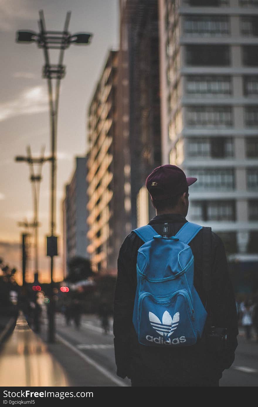 A male urban pedestrian walking outdoors.