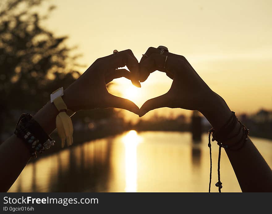 Hands in the shape of a heart during sunset. Hands in the shape of a heart during sunset.