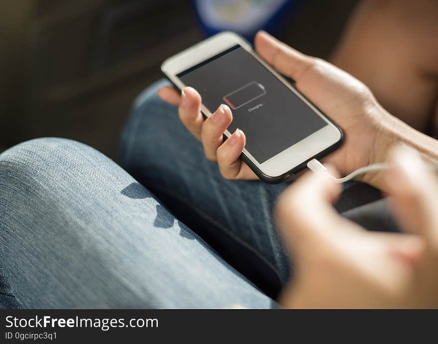 A person holds a charging Ipod.