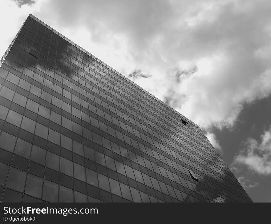 Skyscraper facade on a gray day with low dark clouds. Skyscraper facade on a gray day with low dark clouds.