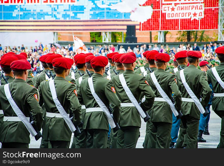 A group of military personal marching outdoors. A group of military personal marching outdoors.