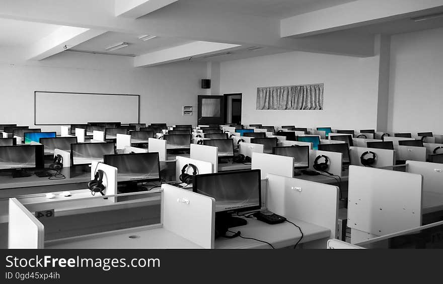 An classroom with cubicles with computers and headsets. An classroom with cubicles with computers and headsets.