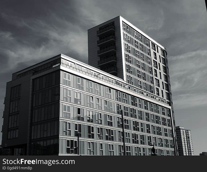 Apartments or office blocks with rectangular shape lacking decoration and with repeated features on a gray day with glowering sky. Apartments or office blocks with rectangular shape lacking decoration and with repeated features on a gray day with glowering sky.