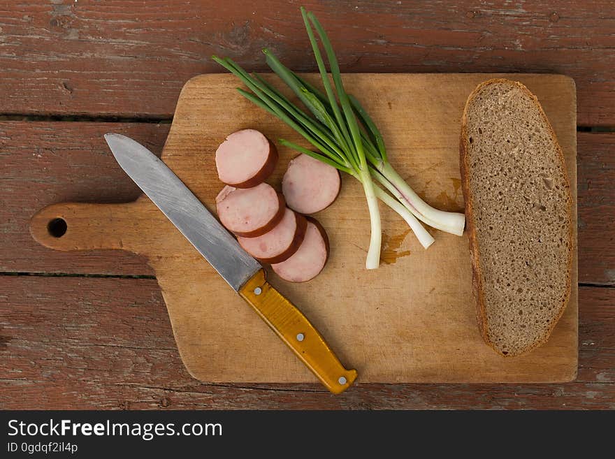 Kitchen Knife Next to Slice Bread on Chopping Board