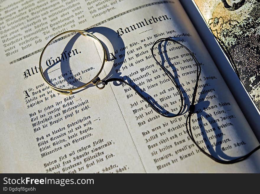 Black String on Top of an Open Book during Daytime