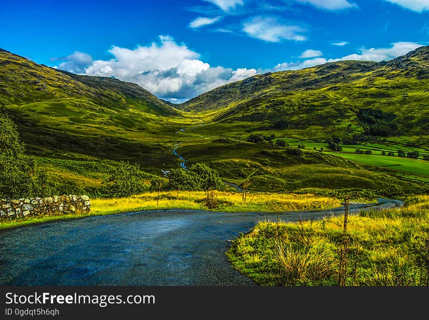 A road passing through green rolling hills. A road passing through green rolling hills.