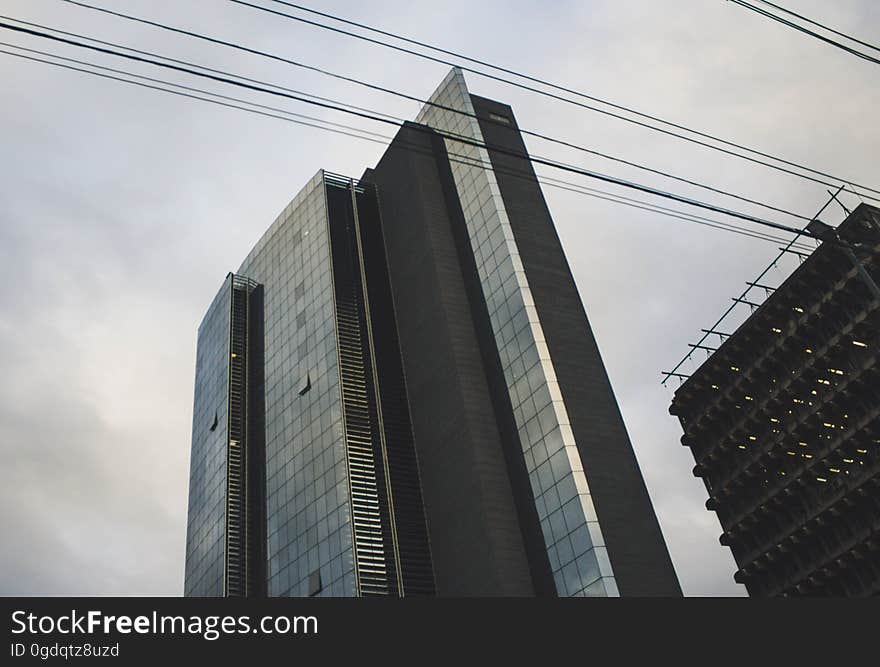 A modern high rise with power lines in front of it.