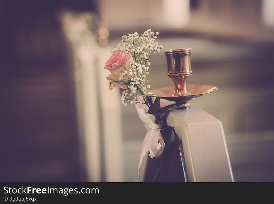 A copper candelabrum with a bouquet of flowers.