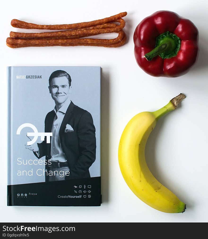 Book entitled "Success and Change" by Mateusz Grzesiak surrounded on three sides by different foods isolated on a white background. Book entitled "Success and Change" by Mateusz Grzesiak surrounded on three sides by different foods isolated on a white background.