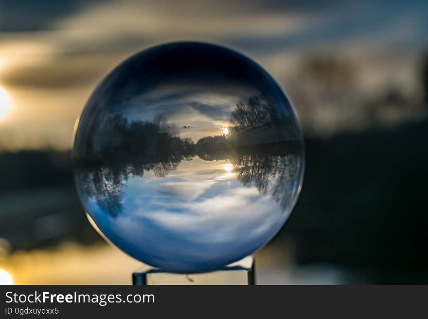 A crystal ball refracting the light with the sunset on the background.