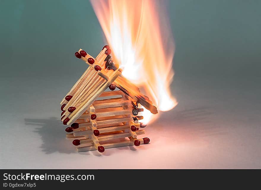 A house made of matchsticks burning in fire. A house made of matchsticks burning in fire.