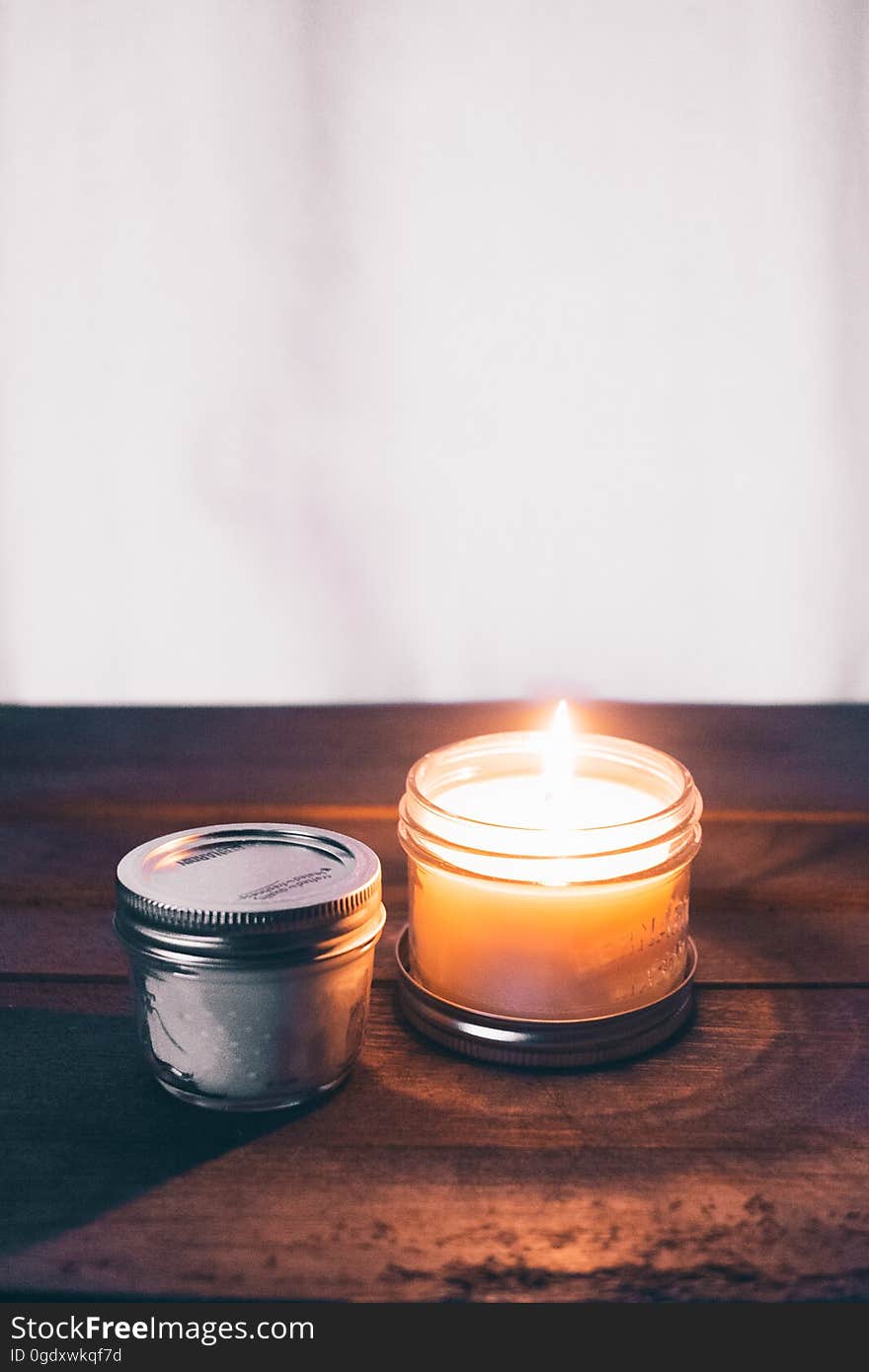 An aromatherapy candle burning on a wooden table.