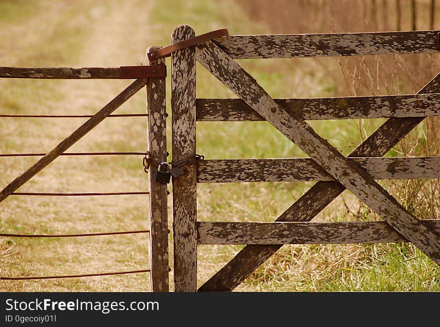 An old fence with a gate on a rural road. An old fence with a gate on a rural road.