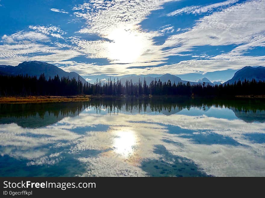 A beautiful lake with a forest and sky reflecting in the water. A beautiful lake with a forest and sky reflecting in the water.