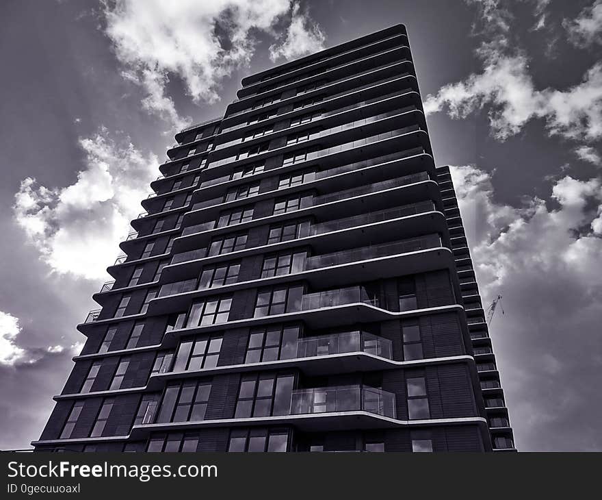 High rise building constructed with glass, steel and concrete but with interesting design features such as bay windows and protruding concrete panels, cloudy sky and unusual angle of view. High rise building constructed with glass, steel and concrete but with interesting design features such as bay windows and protruding concrete panels, cloudy sky and unusual angle of view.