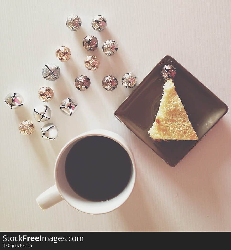 Above view of a cup of coffee, cake and chocolates. Above view of a cup of coffee, cake and chocolates.