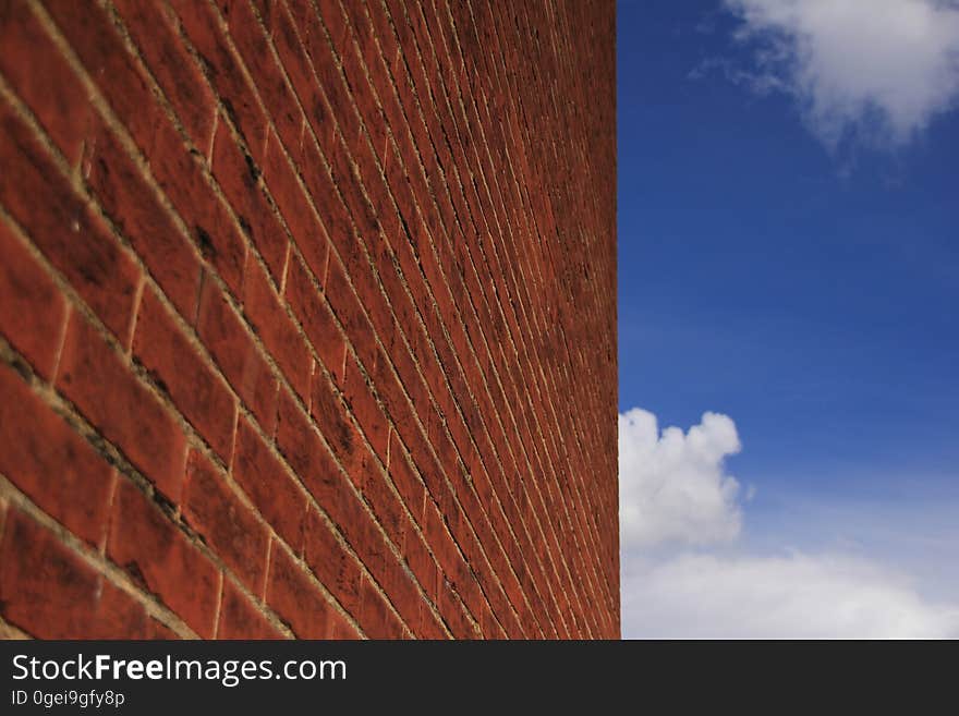 Blue sky with clouds and a wall.