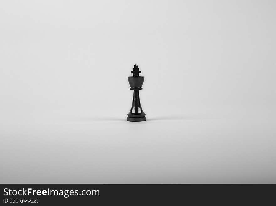 Lone black chess king surrounded by white space. Lone black chess king surrounded by white space.