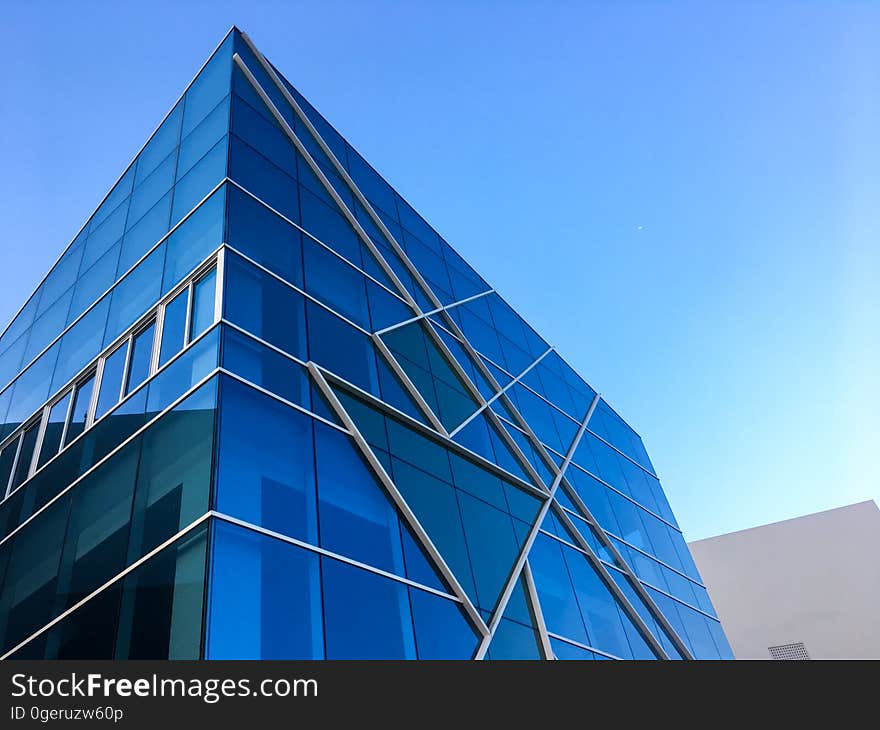 Example of a building with steel, glass and concrete construction which does not conform to simple rectangular panels but incorporates triangular sections, diagonal lines and off axis squares and reflects blue light from the sky. Example of a building with steel, glass and concrete construction which does not conform to simple rectangular panels but incorporates triangular sections, diagonal lines and off axis squares and reflects blue light from the sky.