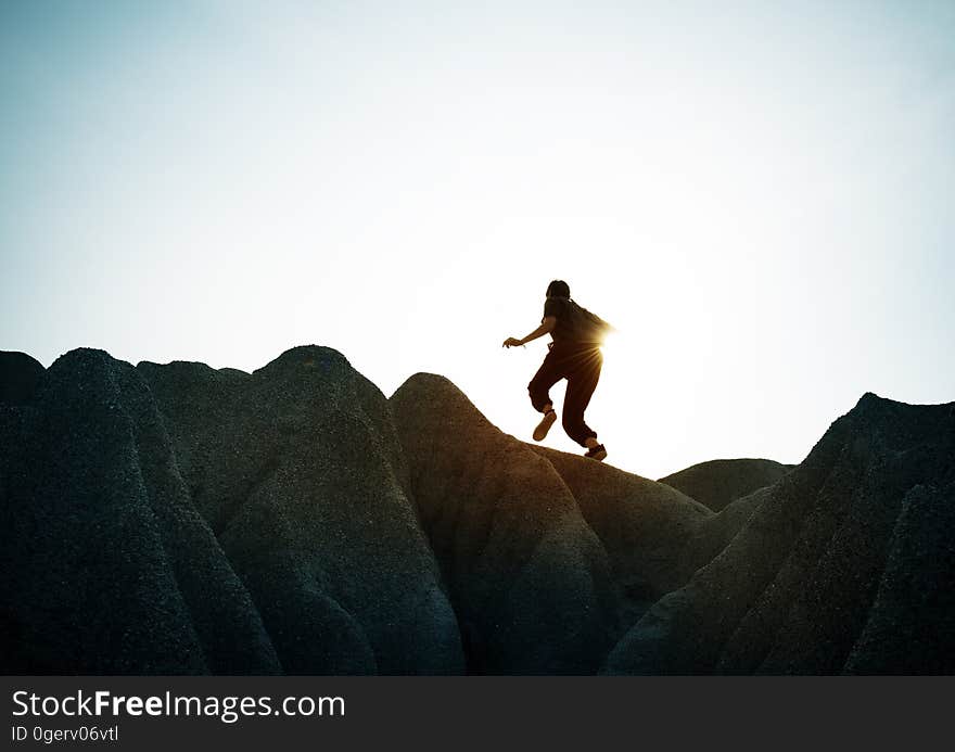 A hiker walking on rocks against the blue sky. A hiker walking on rocks against the blue sky.