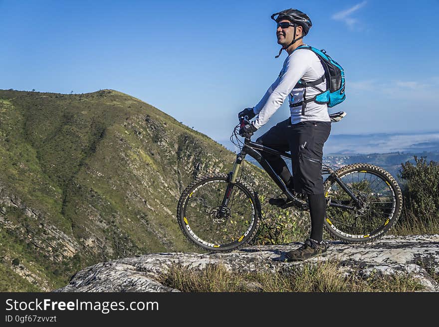 Man With White Shirt Riding Abicycle on a Mountain