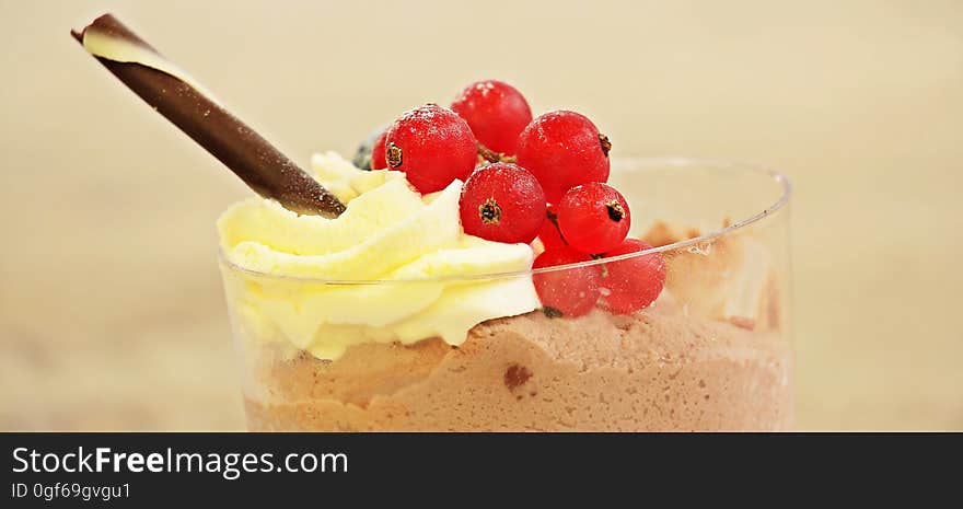 A cup of chocolate mousse with cream and red currants. A cup of chocolate mousse with cream and red currants.