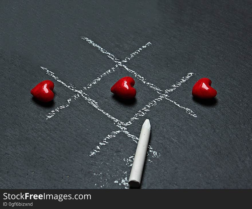 A winning game of tic tac toe played with heart shaped objects. A winning game of tic tac toe played with heart shaped objects.