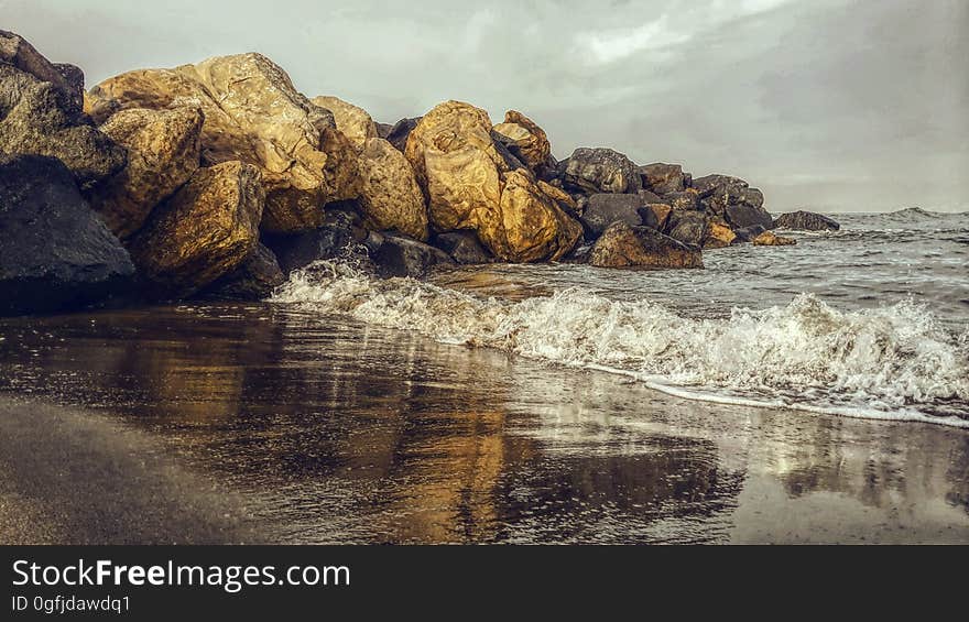 A rocky shore with waves crashing on it.