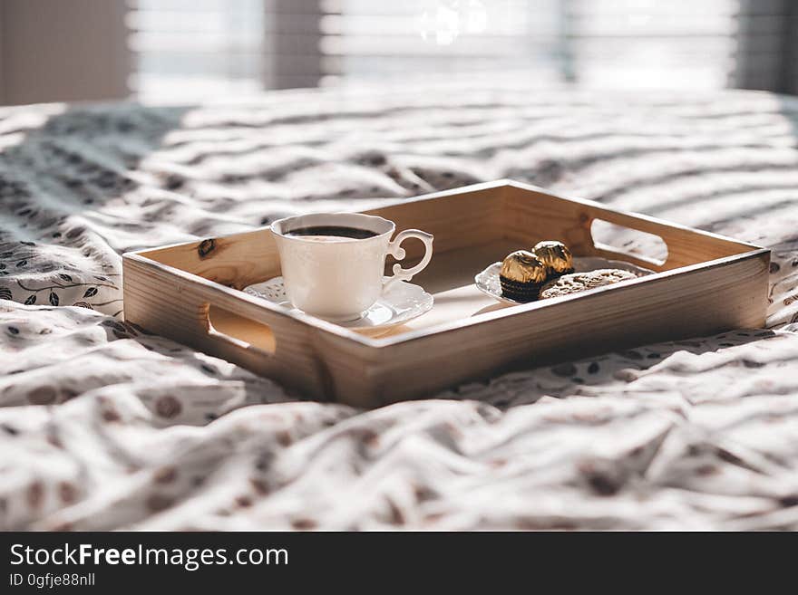 A tray with breakfast on the bed sheet in the morning. A tray with breakfast on the bed sheet in the morning.