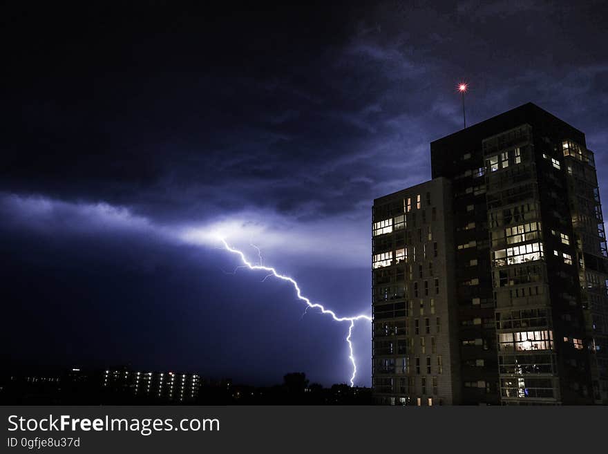 A thunderstorm with a lightning striking in the city at night. A thunderstorm with a lightning striking in the city at night.