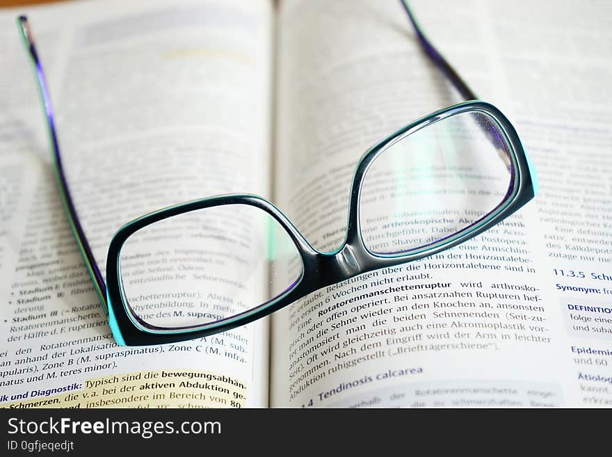 Closeup of reading glasses on a book.