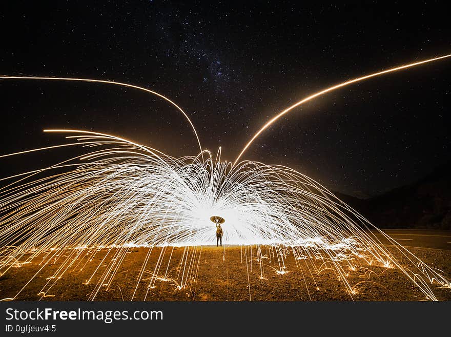 Glowing sparks from flaming steel wool spinning on a dark night. Glowing sparks from flaming steel wool spinning on a dark night.