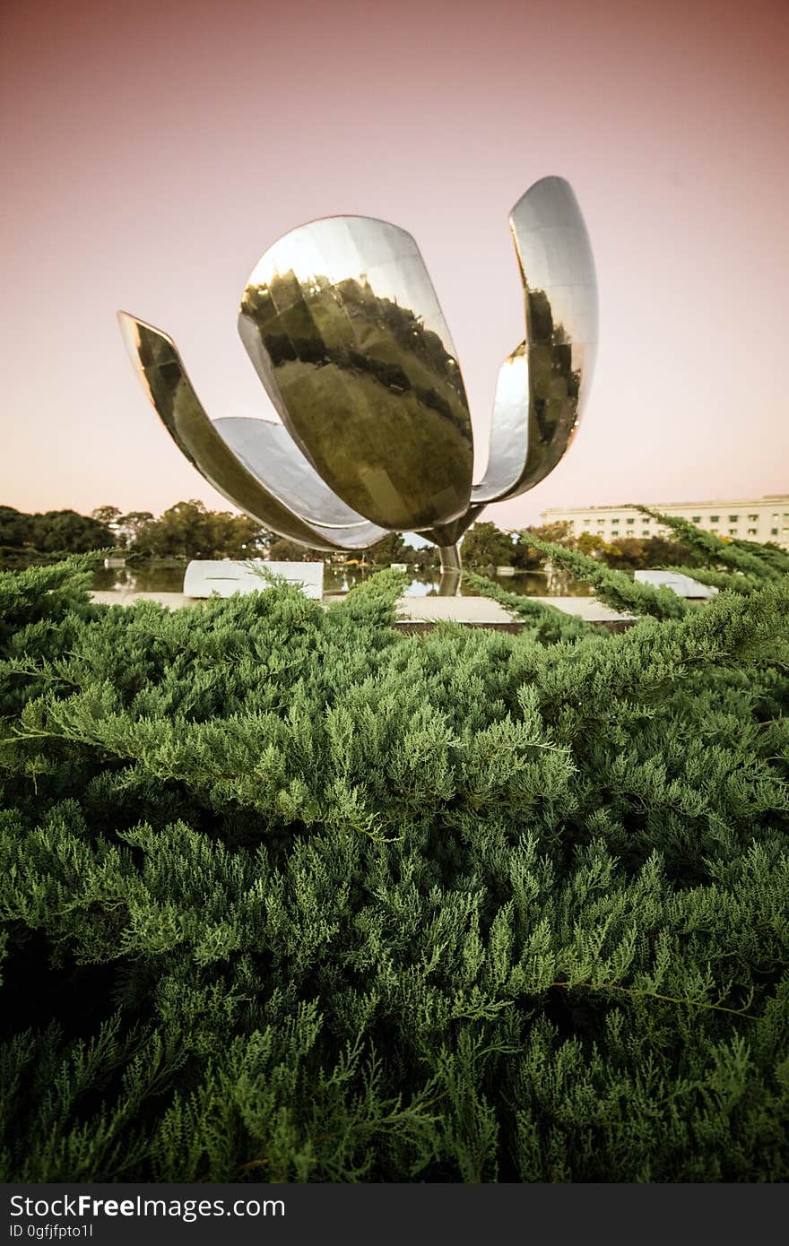 Floralis Generica sculpture designed by Eduardo Catalano reflecting surrounding trees, located in Plaza de Las Naciones Unidas in Buenos Aires, Argentina.