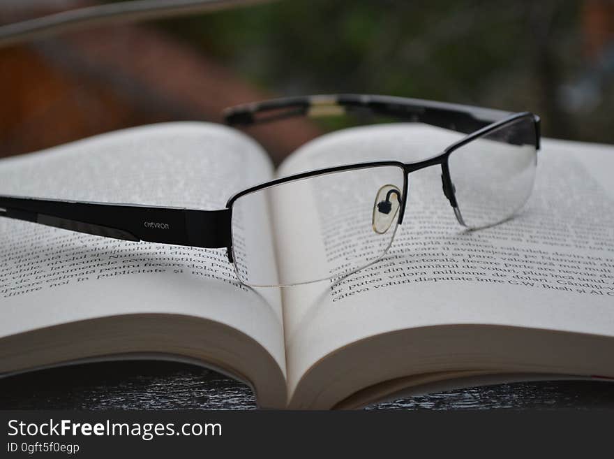 A pair of eyeglasses on an open book. A pair of eyeglasses on an open book.