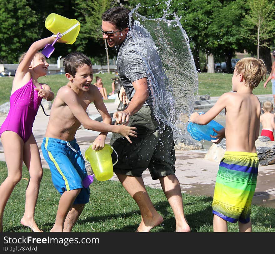 Kid&#x27;s Plating Water on Grass Field during Daytime