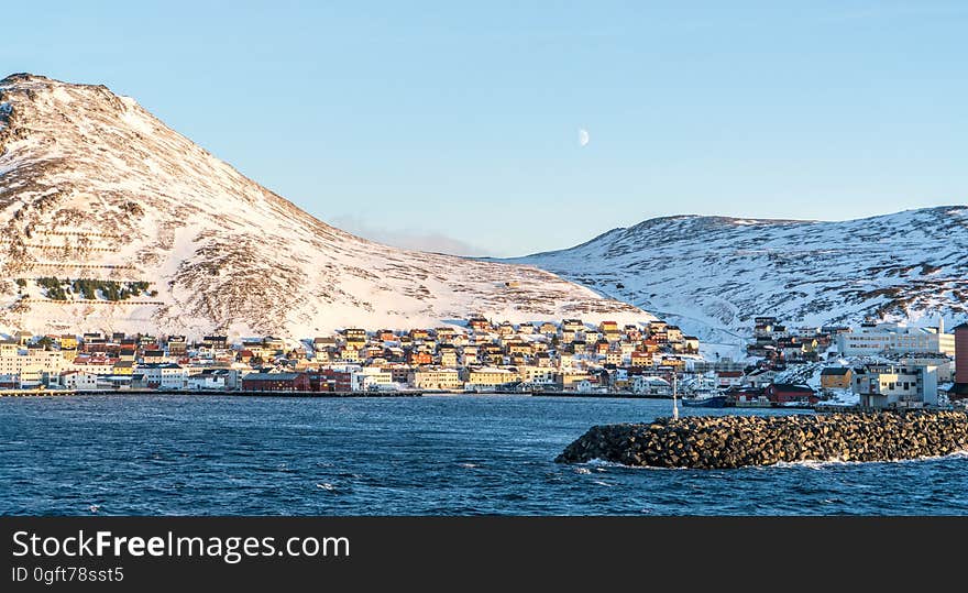 A town on the bay with snowy hills on the distance. A town on the bay with snowy hills on the distance.