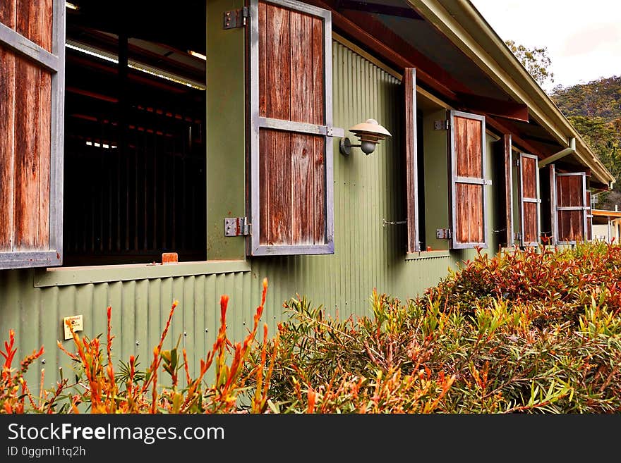 A countryside house with open windows.