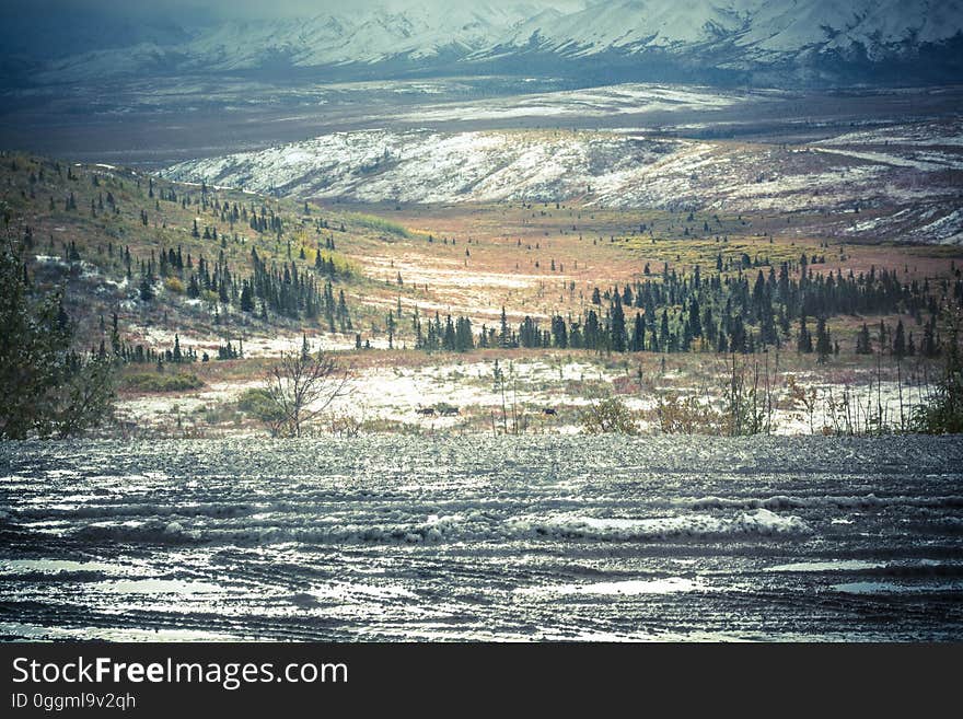 An illustration of mountain landscape with a lake in the foreground.