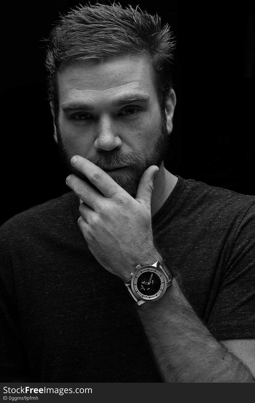 A black and white portrait of an attractive young man with a wrist watch. A black and white portrait of an attractive young man with a wrist watch.