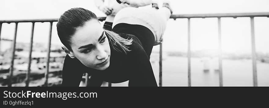 Beautiful young women in sports clothing, training on city bridge