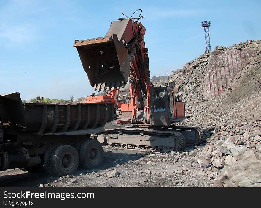 Bulldozer with bucket loads truck